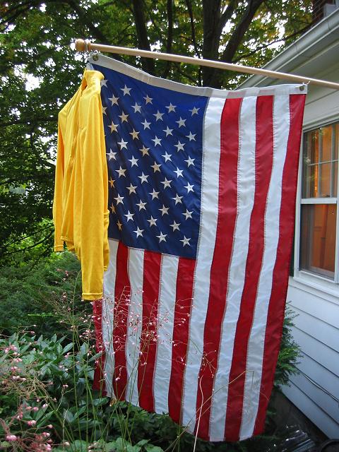 American flag and yellow jersey.  Lance Armstrong becomes the second person to win the Tour de France five times in a row.